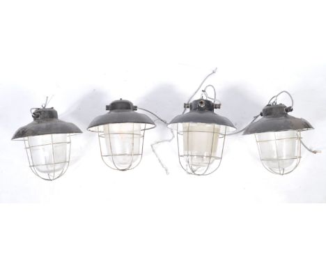 A set of four 20th Century retro vintage industrial porcelain enamel pendant light having steel wire cages, bell glass shade 