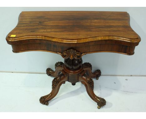 A 19th century rosewood folding card table, of serpentine outline, with green baize, raised on lobed baluster to four down-sw