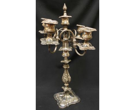 A large silver-plated five light candelabra, embossed all over with flowers, with four scrolling arms and supported on a quat