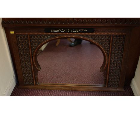 A walnut over-mantel mirror in the Islamic taste, with central mirhab arch surrounded by bobbin-turned trellis and blind fret