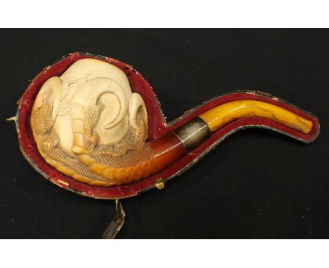 A Meerschaum pipe modelled as a stylized dragon's talons clutching an egg, with amber stem and silver mount.