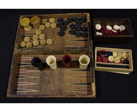 A part set of 28 ivory and stained ivory checkers pieces, together with 14 boxwood and 15 ebony pieces, various other backgam