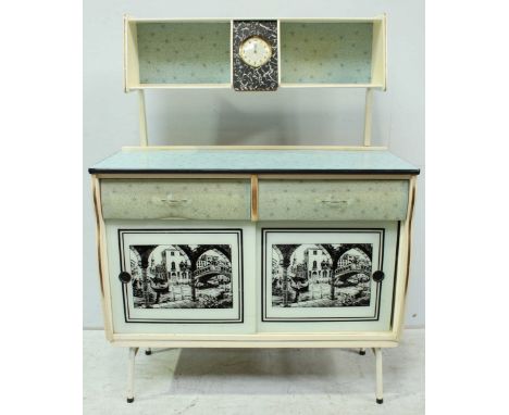 A 1950s Barget Uil retro white painted kitchen dresser, the top with central Smyths clock in a folding flap and shelves eithe