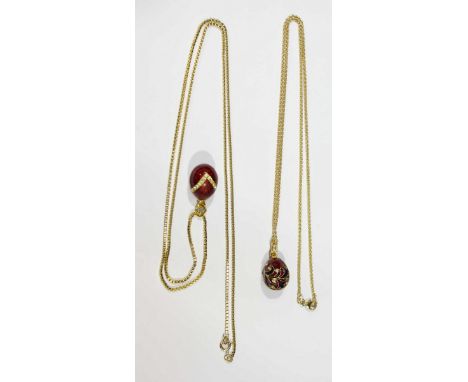 Two yellow metal and enamel egg pendants, on 9ct gold chains. Chains 13.3 grams.