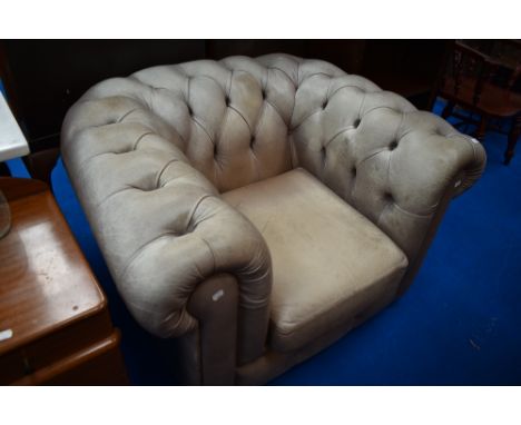 A modern leather chesterfield style armchair in grey, some light scuffing
