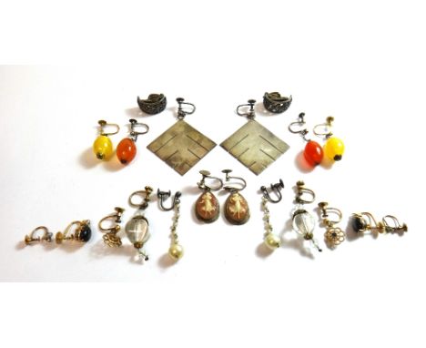 A pair of carved shell cameo drop shaped pendant earrings, each carved as the dancing figure of a lady, a pair of silver earr