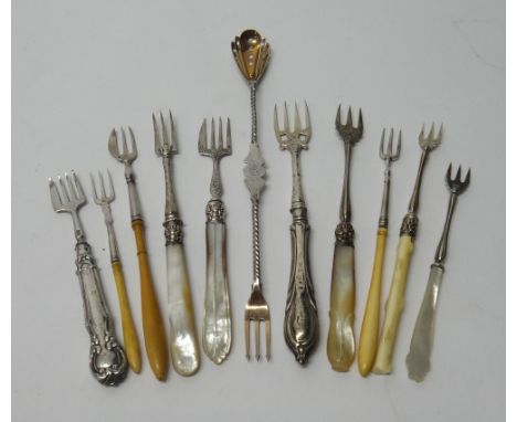 A twin ended pickle fork cum olive spoon, with spiral decoration to the stem and ten further pickle forks, mostly having make
