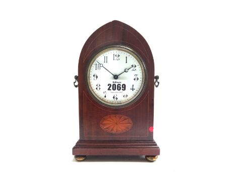 An Edwardian mahogany and inlaid mantel clock, the arched case enclosing a white enamel dial on plinth base and brass feet, 2