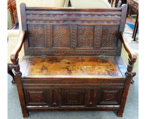 An 18th century and later oak box settle, the triple panel back over lift seat, 102cm wide. 