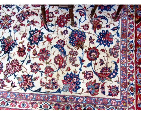 An Esfahan carpet, Persian, the ivory field with an allover palmette and floral spray design; a complementary madder border. 