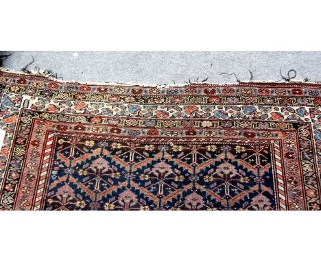 A Fereghan carpet, Persian, the indigo field with rows of plants, with serrated leaves, various borders, 343cm x 168cm.