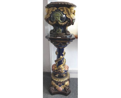 A Continental majolica jardiniere and stand, early 20th century, moulded with anthropomorphic portrait to bowl atop a stand m