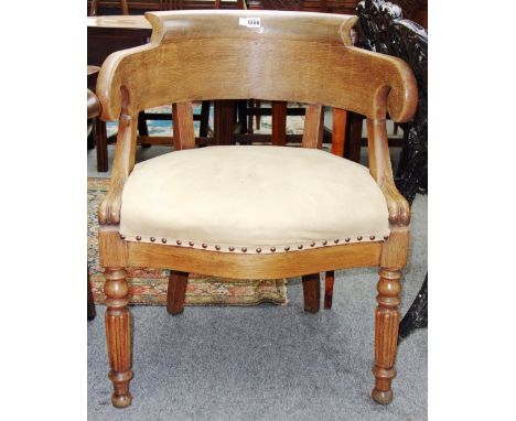 An early 19th century French light oak tub back desk chair on reeded supports.