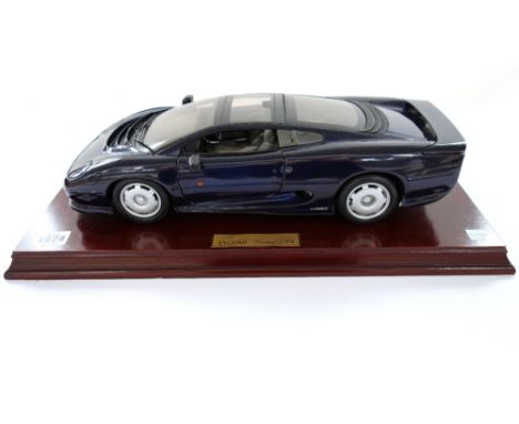 A 1/40 scale model of a Jaguar XJ220, on a wooden plinth base with brass plaque, 47.5cm wide overall.