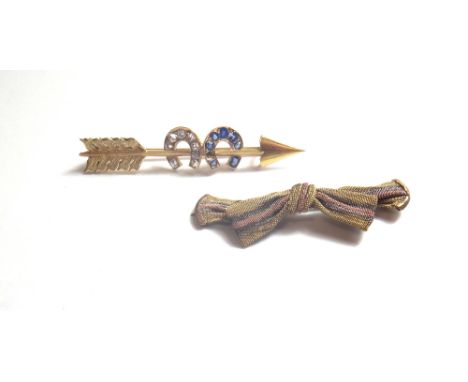 A gold, diamond and sapphire set brooch, designed as an arrow and two horseshoes, mounted with cushion shaped diamonds and sa