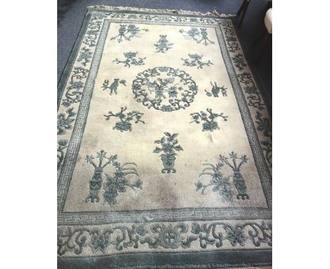 A Chinese carpet the ivory field with a fret roundel, vases and  sprays, a complementary border 280cm x 183cm. 