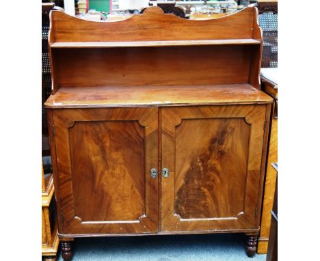 An early 19th century mahogany chiffonier, with concave shelf back over a pair of cupboards, on turned supports, 102cm wide.