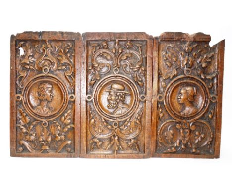A set of three early 17th century carved oak panels, each with central portrait rounded on a floral swag ground, 22cm wide x 