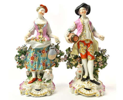 A pair of Derby figures of a shepherd and shepherdess, circa 1770, each standing with a dog or sheep at their feet, he carryi