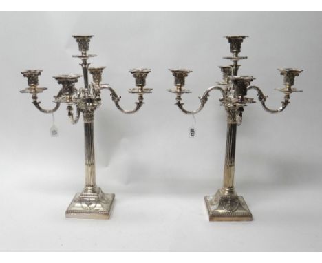 A pair of silver plated five light table candelabra, each of Corinthian column form, with scrolling arms and on a swept squar