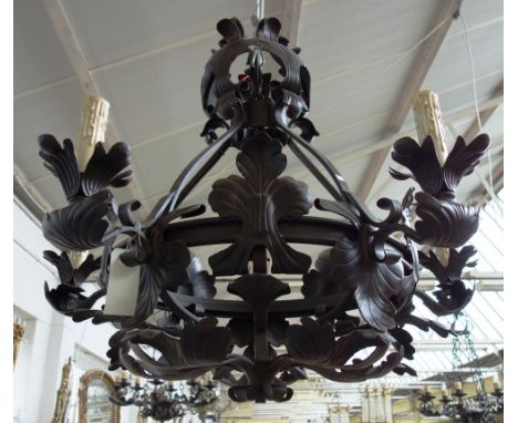 An English wrought iron five light chandelier, late 20th century, with a cage frame applied with large scrolling foliage, 102