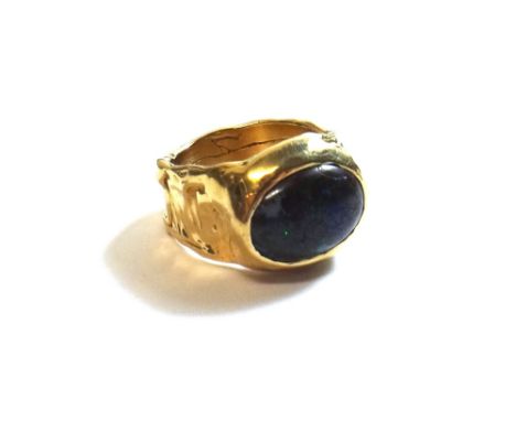 A gold ring mounted with an oval wood opal, detailed Cotter 14K, ring size M and a half, gross weight 14 gms. 