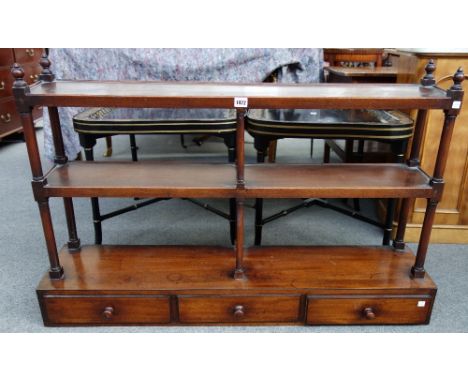 A 19th century mahogany wall shelf of three tiers, the lower with a trio of drawers, on turned supports, 112cm wide.