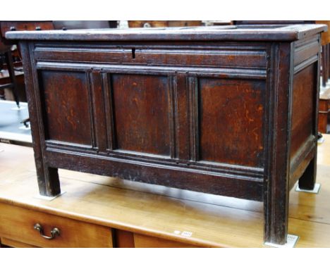 A late 17th century oak coffer, with triple panel lid and front on stile feet, 106cm wide. 