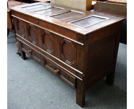 An 18th century oak mule chest, with four panel top and front over a pair of drawers, on stile feet, 136cm wide.
