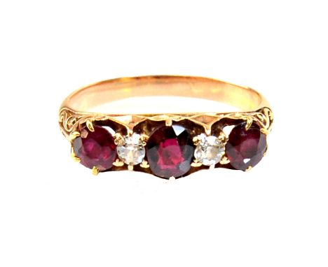 A gold, ruby and diamond set five stone ring, mounted with three cushion shaped rubies, alternating with two cushion shaped d