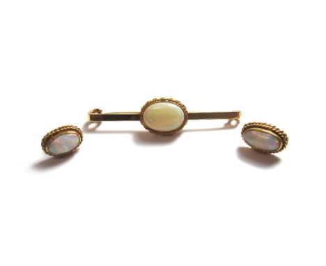 An 18ct gold and opal set single stone bar brooch, mounted with an oval opal within a ropetwist wirework surround, Birmingham