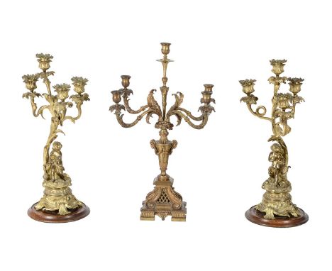 A PAIR OF GILT METAL THREE BRANCH CANDELABRA 19TH CENTURY Each with a seated cherub on a Rococo scroll base, allegorical of w