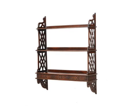 AN EDWARDIAN FLIGHT OF THREE MAHOGANY WALL SHELVESCIRCA 1905, AFTER THE MANNER OF THOMAS CHIPPENDALEWith arrangement of three