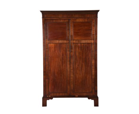 A GEORGE IV FIGURED MAHOGANY WARDROBECIRCA 1825, IN THE MANNER GILLOWSThe panel doors enclosing a hanging rail and arrangemen