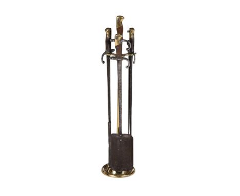 A SET OF GILT BRASS, IRON, AND WOOD MOUNTED FIRE TOOLS AND STAND Each in the form of a sword The stand 80cm high 