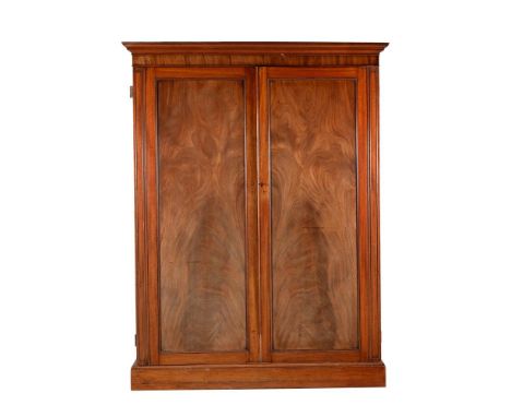 A GEORGE IV MAHOGANY LINEN PRESSCIRCA 1825The panel doors enclosing a hanging space, slides, and drawers190cm high, 142cm wid