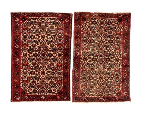 Near pair of Persian Herati red ground rugs, each rug decorated with two large complete Herati motifs, surrounded by stylised