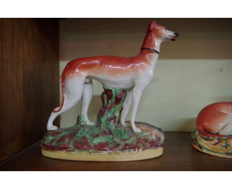 A matched garniture of five Victorian Staffordshire pottery greyhound and rabbit figure groups, largest 29cm high.