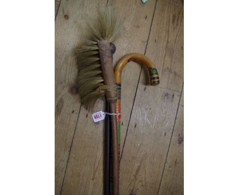 A carved and polychrome painted walking stick; together with a hard wood cane; and another.