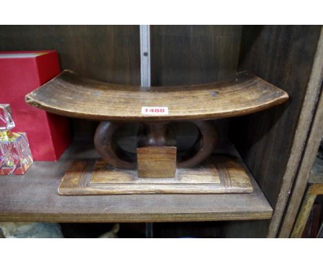 Ethnographica: an African carved wood head rest, 29cm wide; together with a stoneware vase.