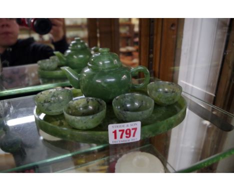 A Chinese green jade wine set, comprising a pot and cover; four bowls; and an oval tray, 20cm wide.  Condition Report: All pi