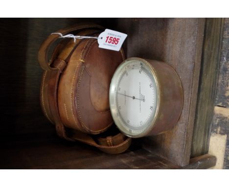 A World War II period brass aneroid barometer, in leather case.  Condition Report: In working order.  Reading today 31+