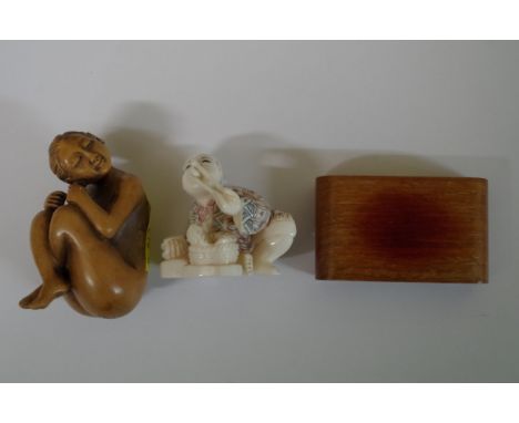 A Japanese carved wood erotic netsuke, signed, 5cm; together with another Japanese carved ivory netsuke on wood stand.