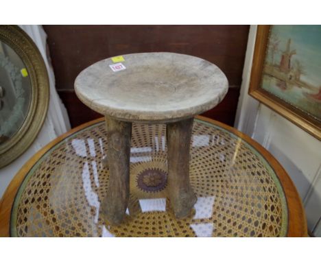 Ethnographica: a tribal wood four legged stool, 29cm diameter.