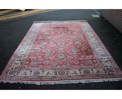A large machine made carpet of Persian floral design on pink field. 411 x 300cm.