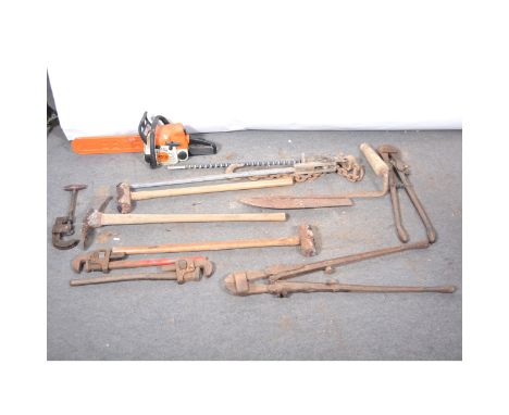 Two sledge hammers, a pick axe, two bolt croppers, two bolt wrenches, pipe cutter, chain saw, still iron, silage cutter and a