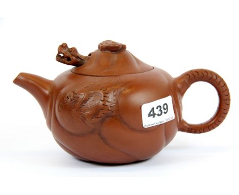 A Chinese handmade Yixing terracotta teapot with dragon decoration and articulated dragon head in the lid, H. 11cm.