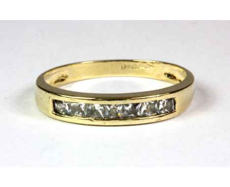 A 9ct yellow gold stone set half eternity ring, (N.5).