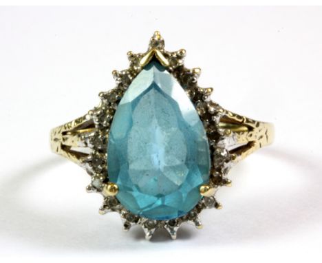 A 9ct yellow gold pear cut blue topaz and diamond cluster ring, (R).