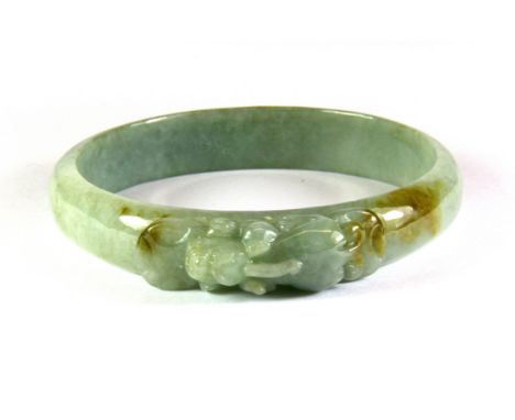 A carved jade bangle with a dragon on the top, Dia. 8cm.